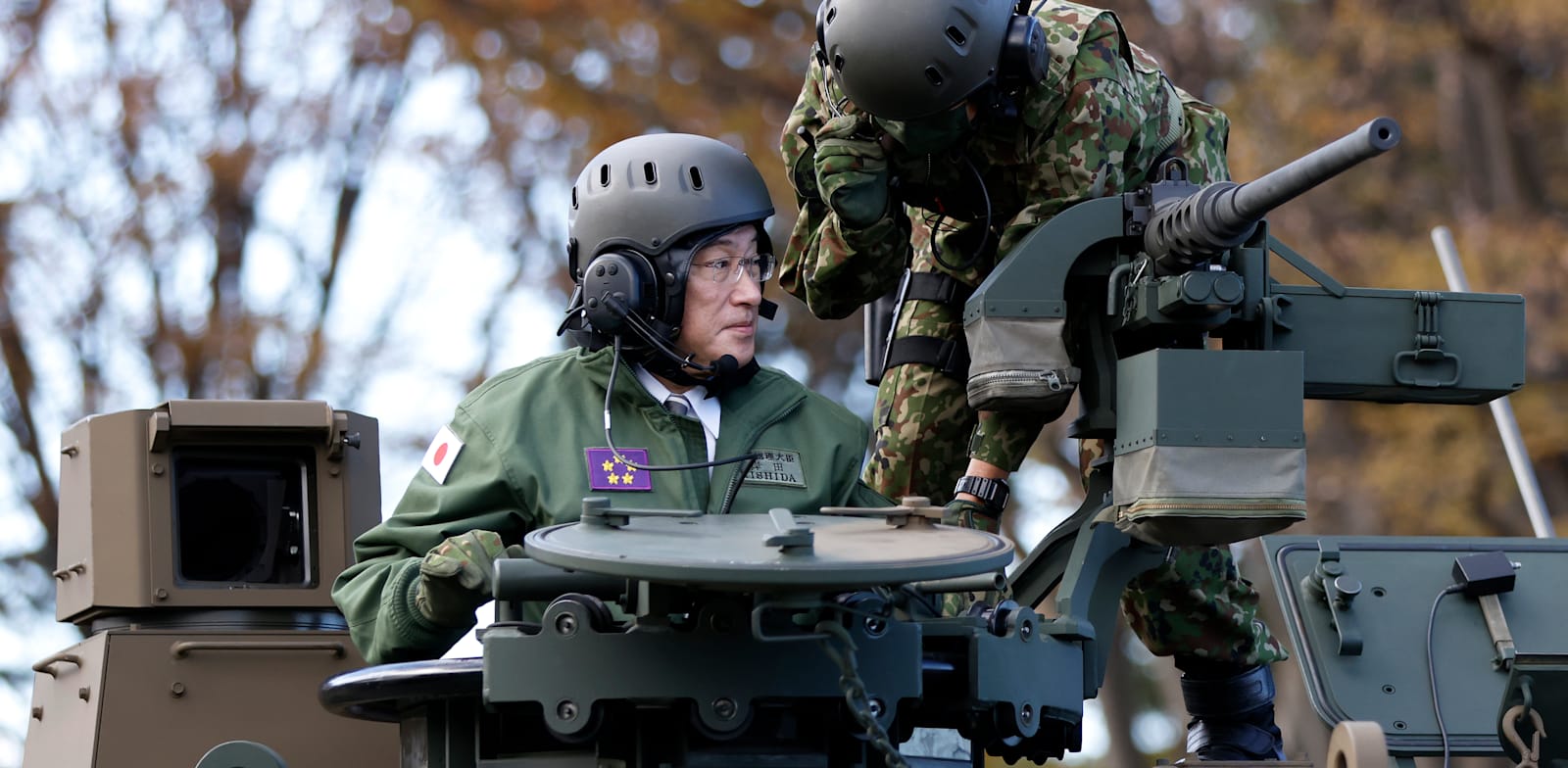 ראש ממשלת יפן, פומיו קישידה, רוכב על טנק במהלך סקירה ביטחונית / צילום: Associated Press