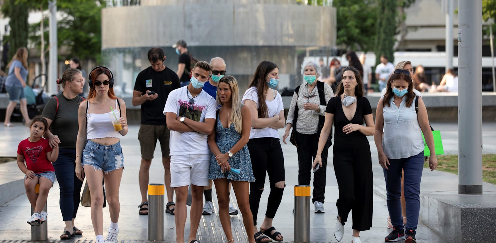 אנשים עוטים מסכות עומדים במעבר חצייה בתל אביב ביוני האחרון / צילום: Reuters, Amir Cohen