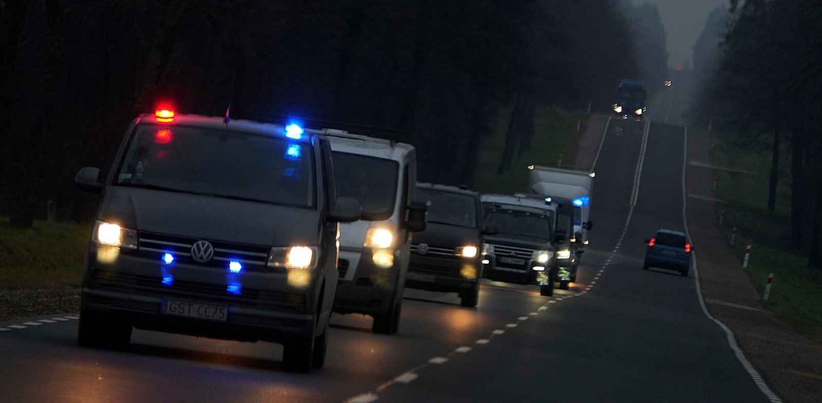 ניידות משטרה פולניות נוסעות חזרה מהגבול עם בלארוס, סמוך לכפר קוזניצה / צילום: Associated Press, Matthias Schrader