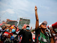 מפגינה מצביעה בשלוש אצבעות, סמל המאבק, זאת לאחר שמפגינה נורתה בראשה ע"י המשטר הצבאי במסגרת ההפגנות / צילום: Associated Press