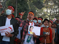 צעירים מפגינים אוחזים תמונה של ראש ממשלתם העצורה / צילום: Associated Press