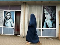 אישה בבורקה עוברת מול מכון יופי / צילום: Associated Press, Allauddin Khan