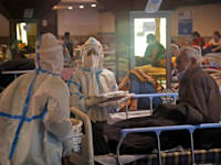 צוות רפואי עובר בין החולים במרכז בידוד בניו דלהי. הצוותים הרפואיים קורסים תחת עומס החולים ברחבי המדינה / צילום: Associated Press, Manish Swarup