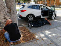 תושבים באשקלון תופסים מחסה בזמן נפילת הרקטות / צילום: Associated Press, Ariel Schalit