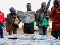 קנייאתים מעיינים בעיתונים המקומיים שדיווחו בהרחבה על חשבונות הבנק הסודיים של הנשייא, שנחשפו במסמכי פנדורה, השבוע / צילום: Associated Press, Brian Inganga