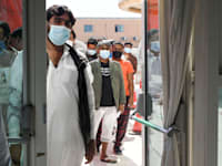 אנשים עומדים בתור כדי לקבל חיסון לקורונה באבו דאבי / צילום: Reuters, Khushnum Bhandari