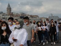 עוברי אורח הולכים על גשר אמינונו באיסטנבול / צילום: Associated Press, Yasin Akgul