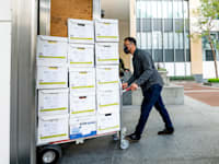 חבר בצוות עורכי הדין של אפל מוביל מסמכים לדיון בבית המשפט / צילום: Associated Press, Noah Berger