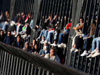 צעירים גרמנים נהנים מהשמש על הגשר האקר־בריקה במינכן, בחודש מרץ / צילום: Associated Press, Matthias Schrader