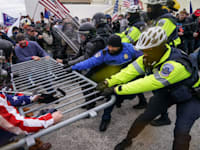 ההסתערות על הקפיטול בינואר שעבר. נאמני טראמפ  מנסים לפרוץ מחסום משטרתי / צילום: Associated Press, John Minchillo
