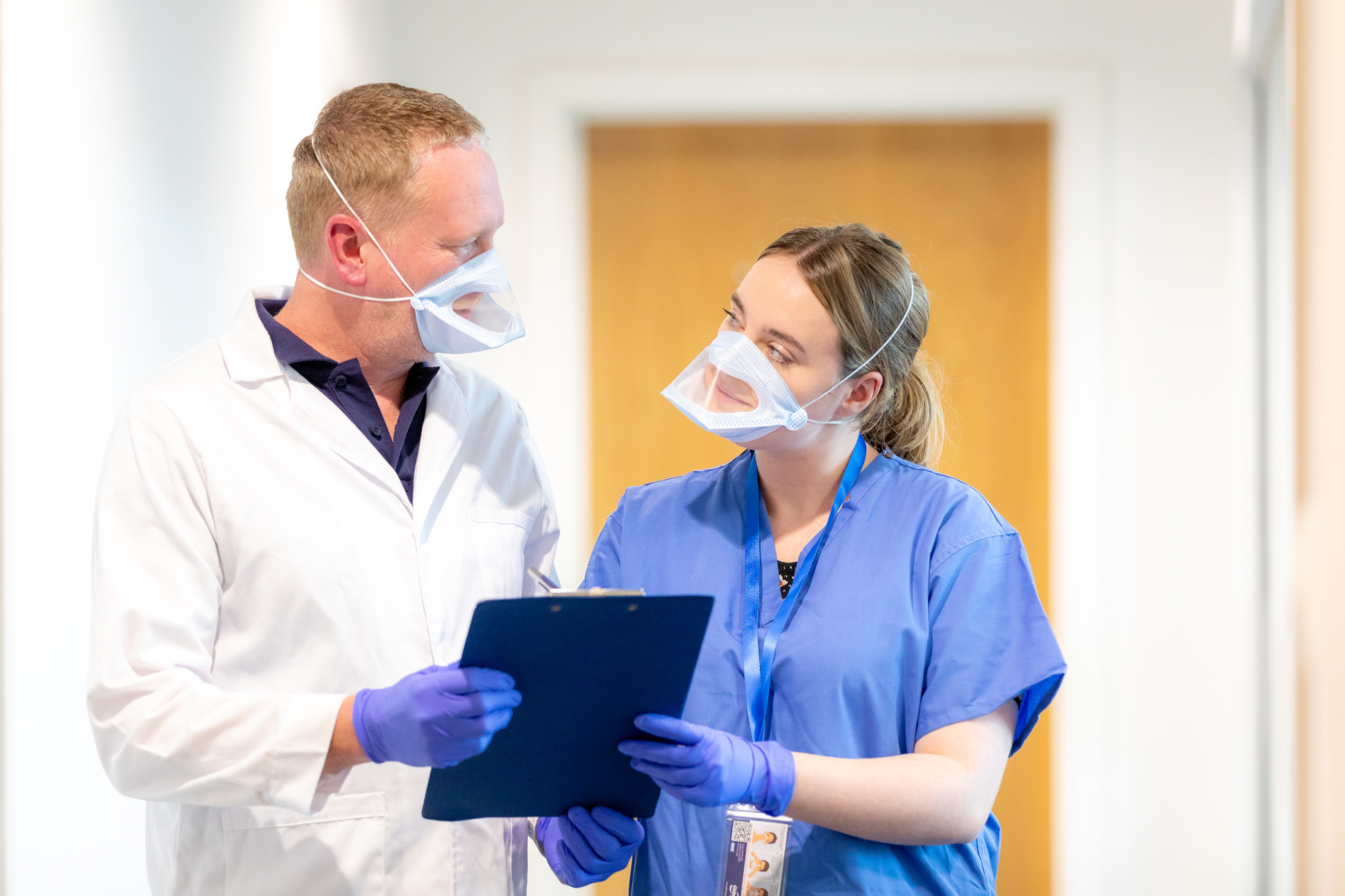 A woman and a man wearing UK-made transparent face masks