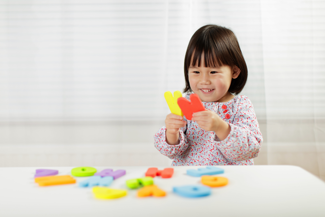 3歳の子どもがオンライン英語レッスン後にアルファベットを見ながら喜んでいる様子