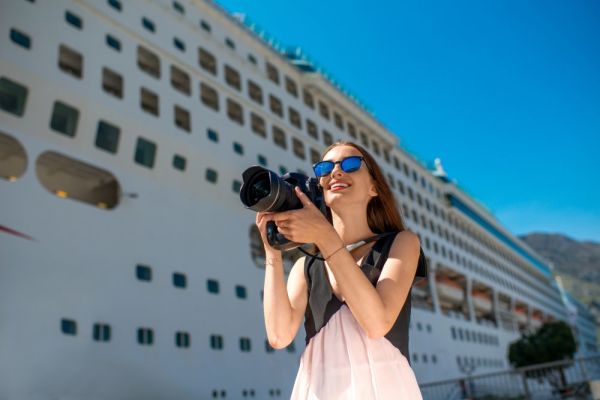Frau vor Kreuzfahrtschiff