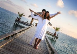 Sensual happy couple in white clothes on a pier (Maldives)