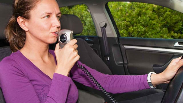 a woman blowing into a baiid to start a vehicle
