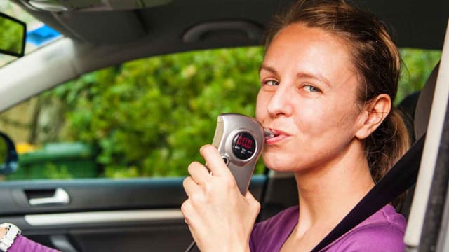 a woman blowing a 0.0 on a BAIID to start her car