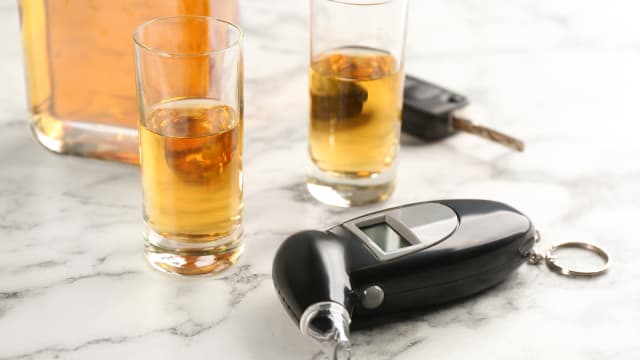 Shots of alcohol with a breathalyzer machine and car keys