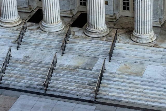 white marble columns on top of steps
