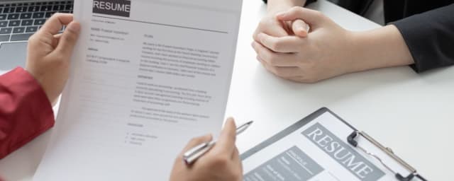employer looking at a background check during a job interview
