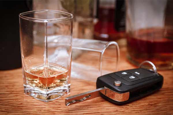 llaves de auto y vasos de alcohol en un bar
