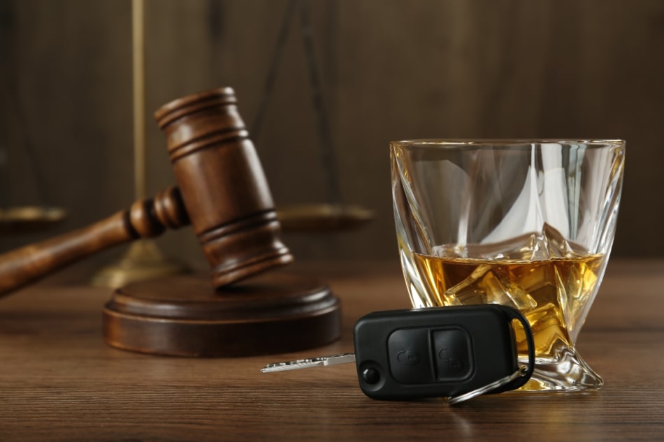 Gavel, whiskey, and keys symbolizing legal consequences