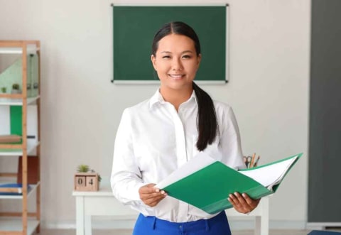 a female teacher at the head of a class room