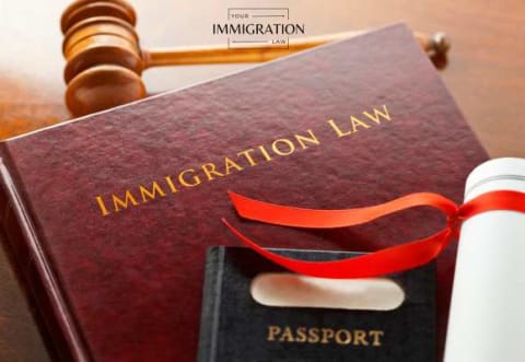 a passport, immigration law book, and gavel on a table