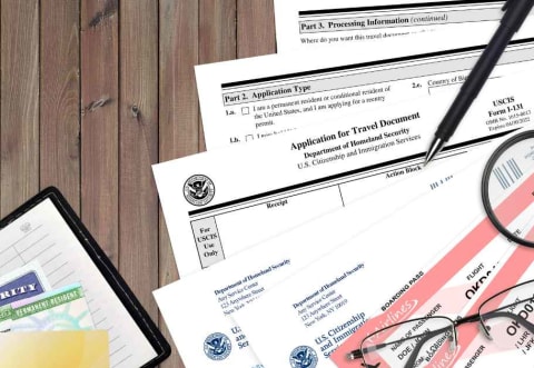 immigration forms, plane tickets, and poassports on a desk