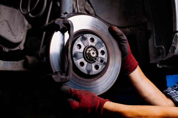 a man services brakes on a car