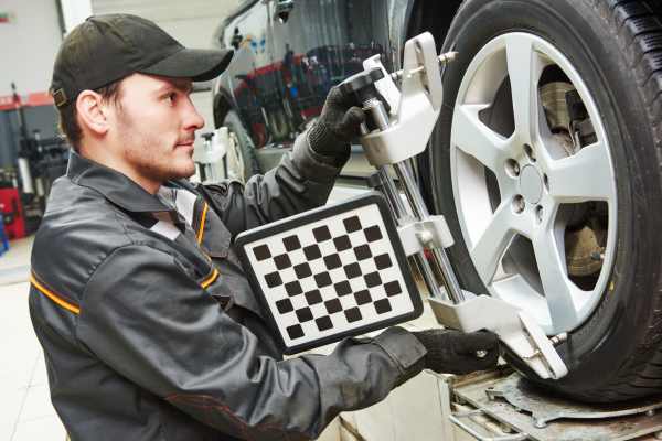 a man aligning wheels on a car