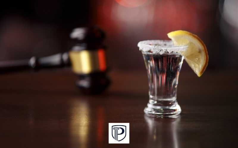 a tequila shot and gavel on a desk