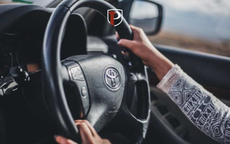 a woman driving a car with a restricted license