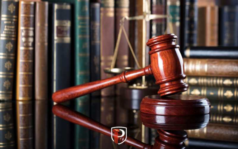 a gavel on a glass table in front of law books