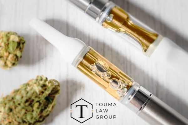 a vape pen, thc cartridges, and marijuana on a table