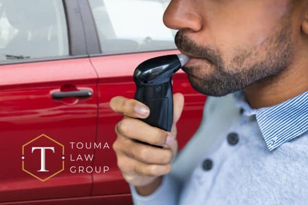 a man blowing into a breathalyzer before being able to drive his vehicle