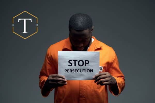 a victim of racial profiling holding a sign that says "stop persecution"