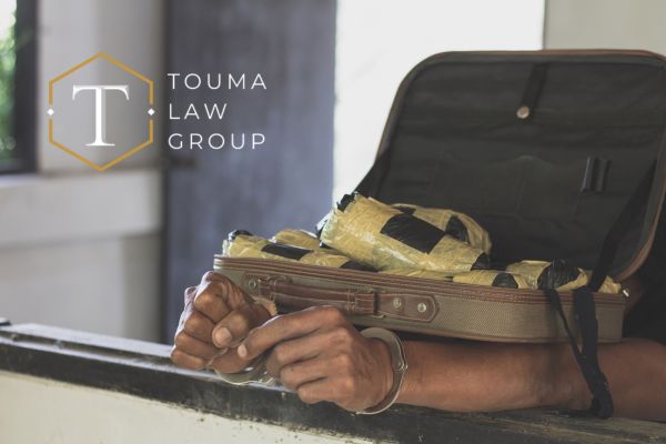 a person in handcuffs with a suitcase full of drugs