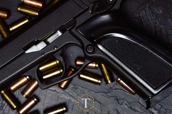 a pistol and ammo on a black table