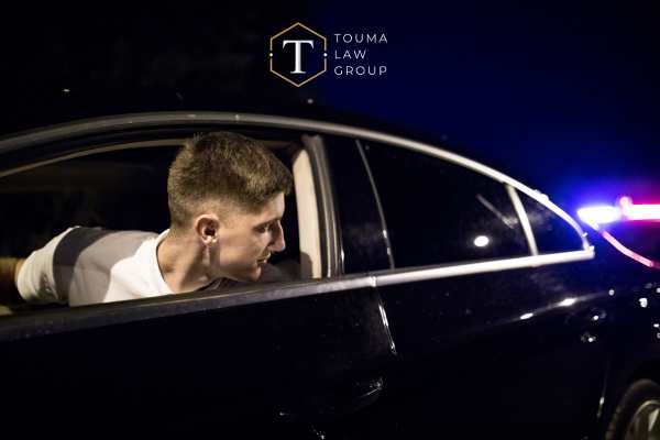 a man looking outside his car window after being pulled over