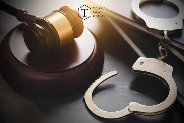 handcuffs and a gavel on a black desk