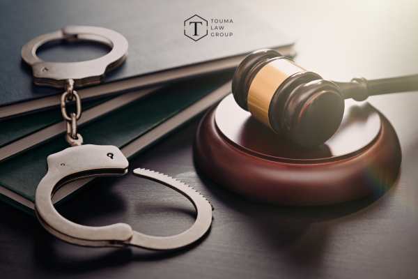 handcuffs and a gavel on a wooden desk