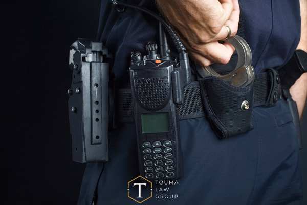 a police officer reaching for his handcuffs