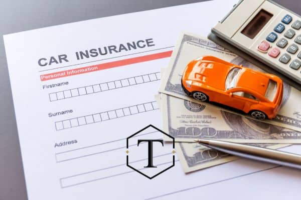 a model car and insurance paperwork on a desk