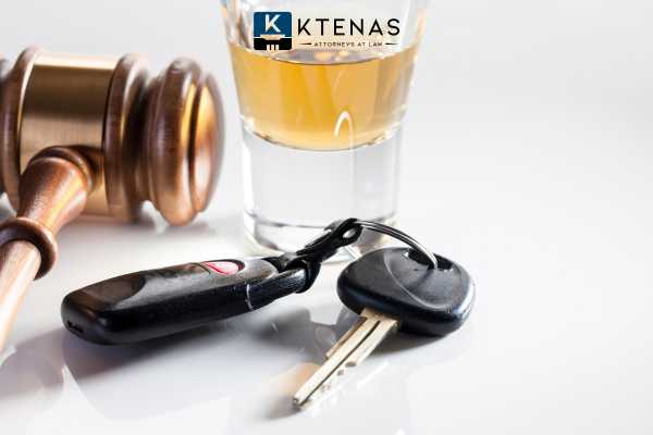 a gavel, shot, and car key on a white table