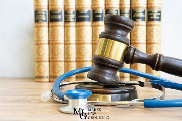 a gavel and stethoscope on a desk in front of law books