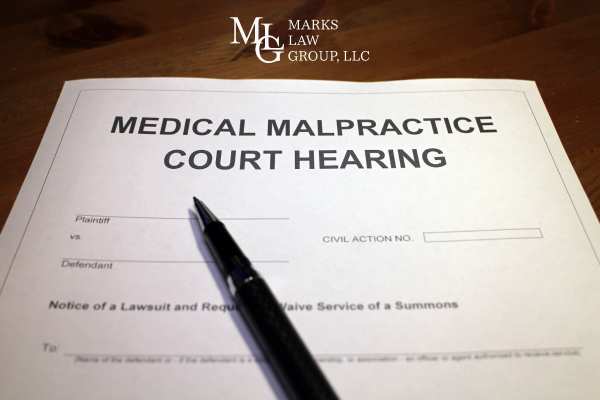 a form for a medical malpractice court hearing and pen on a desk
