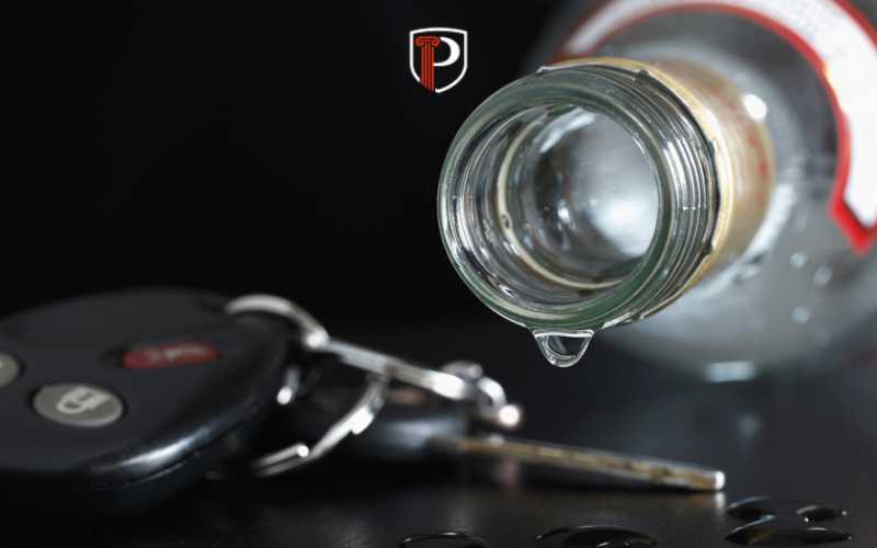 an alcohol bottle and car key on a black table