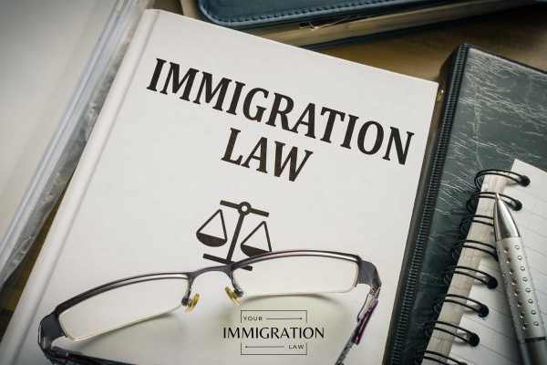 legal books for immigration cases and glasses on a desk