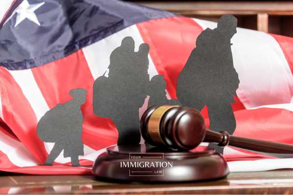 a table with a cut out of a family of immigrant in front of a US flag and gavel on it