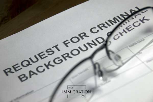 glasses and a background check form on a desk